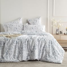 a white bed with blue flowers on it