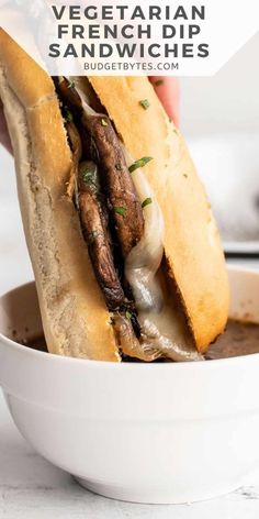 a hand holding a sandwich in a white bowl with the words vegetarian french dip sandwiches above it