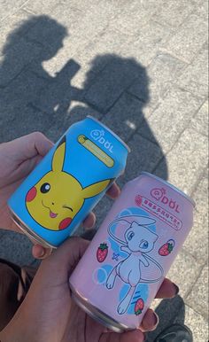 someone holding two cans of pokemon pikachu and strawberry yogurt