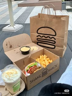 an open takeout box with food and drink on the table