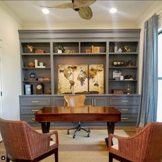 two chairs are in front of a desk with a bookcase on the far wall