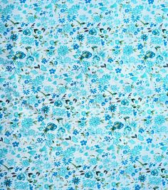 a blue and green flowered fabric with small flowers on the bottom half of it