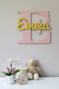 a teddy bear sitting on top of a white table next to a vase with flowers