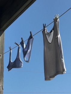 two bras hanging on a clothes line with blue sky in the background