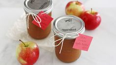 three jars filled with apples sitting next to each other