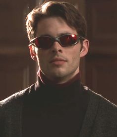 a man wearing sunglasses and a turtle neck sweater