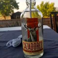 a glass bottle with an image of a deer on it sitting on top of a table