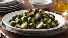 a white bowl filled with brussel sprouts on top of a wooden table