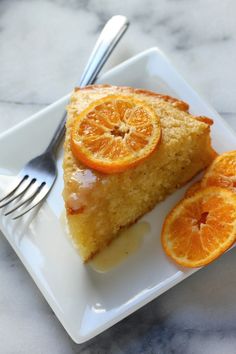 a slice of orange cake on a plate with two slices cut out and fork next to it