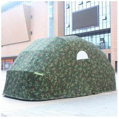 there is a camouflage covered tent on the street