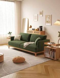 a living room with a green couch and coffee table in front of a large window