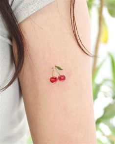 two cherries tattoo on the left arm