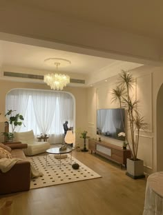 a living room filled with furniture and a flat screen tv sitting on top of a wooden floor