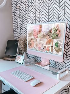 a desk with a keyboard, mouse and monitor on it in front of a patterned wall