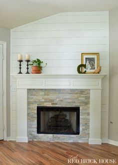 a fireplace with white painted walls and wood floors