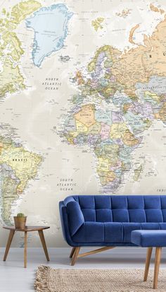 a blue couch in front of a wall with a large world map on the wall