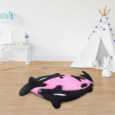 a black and pink cow rug on the floor next to a teepee tent