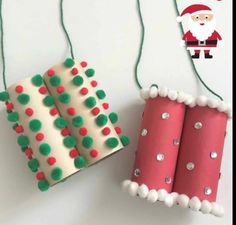 two christmas decorations made out of rolled up paper and some string with santa clause on it