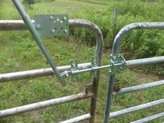 a metal gate in the middle of a grassy field