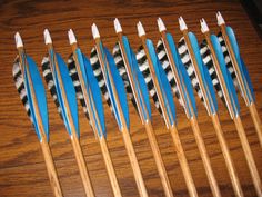 several toothbrushes lined up next to each other on a wooden table with blue and white tips