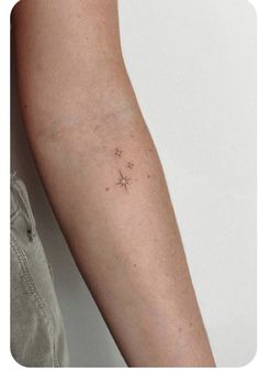 a woman's arm with small stars on the left side of her right arm