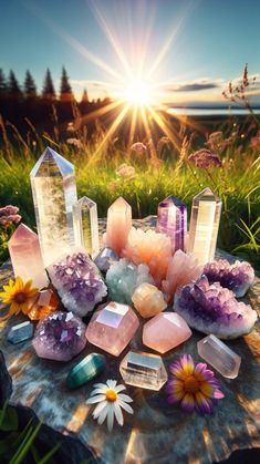 crystals and flowers on a rock with the sun shining in the background, near some wildflowers