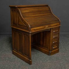 an antique wooden desk with drawers on the top and bottom, sitting on carpeted floor