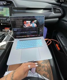 a person sitting in a car with a laptop on their lap