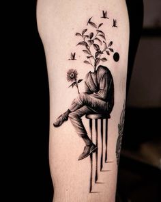 a man sitting on top of a chair next to a flower and birds flying around