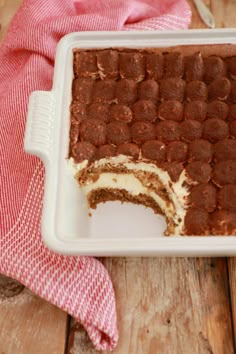 a close up of a cake in a pan on a table with a red and white towel