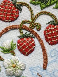 the embroidery work is done with different colors and designs on it, including strawberries