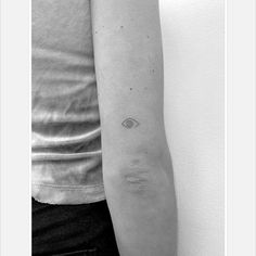 a woman's arm with a small eye tattoo on the left side of her arm