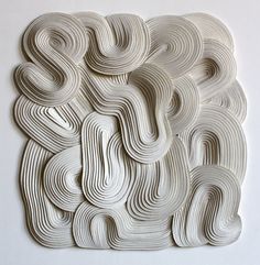 an intricately designed piece of paper on a white surface, with wavy lines in the middle