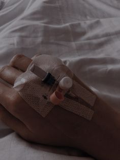 a person's hand with an iv attached to the arm, on top of a bed