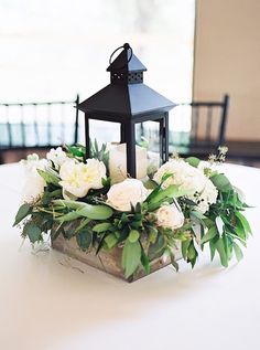 a table with a lantern and flowers on it