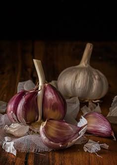 three garlics on a wooden table next to each other