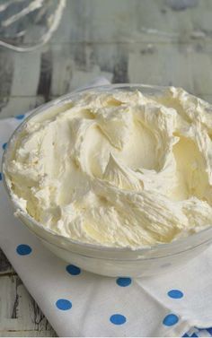 a bowl filled with whipped cream sitting on top of a blue and white polka dot table cloth