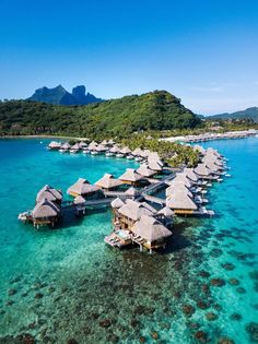 an aerial view of some huts in the water