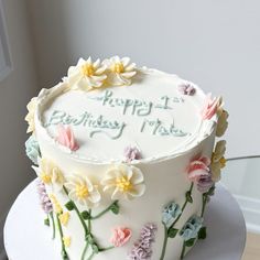 a birthday cake decorated with flowers on a table