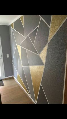 the wall is painted with gold and silver geometric designs on it, along with a white door