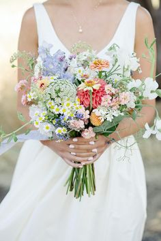 a woman holding a bouquet of flowers in her hands