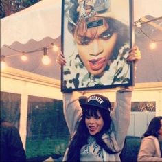 a woman holding up a poster in front of her face