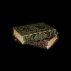 an old book sitting on top of each other in front of a black background,