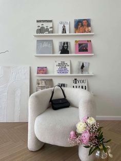 a white chair sitting next to a vase filled with flowers