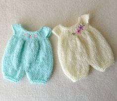 two knitted baby clothes laying next to each other