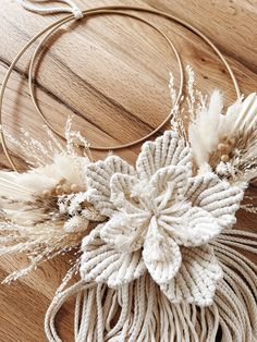 a close up of a piece of rope on a table with some flowers and feathers