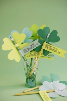 a vase filled with paper shamrocks on top of a table