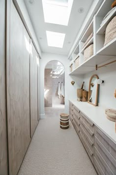 an empty walk - in closet with white walls and wooden cabinets, along with baskets on the shelves