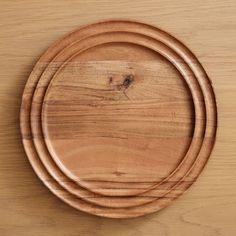 three wooden plates stacked on top of each other with one empty plate in the middle