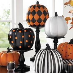 pumpkins decorated with black and white stripes sit on a table